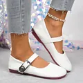 Detailed view of white retro Mary Jane flats with rose buckle and burgundy sole. - 36 / White