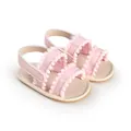 Soft pink baby walking shoes featuring decorative pom-pom trim and adjustable straps - 11cm / Pink