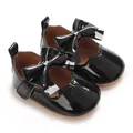 Détail de chaussures de marche en vernis noir avec grand nœud pour bébé fille - Noir