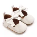 Détail de chaussures de princesse blanches pour bébé avec nœud et bordure ondulée - Blanc