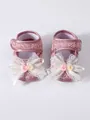 Close-up detail of adorable pink baby girl princess shoes with lace and ribbon bow decorations - Dusty Pink