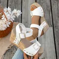 Stylish women's white wedge sandals featuring gold rivets and a textured cork platform - White