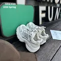 Vue détaillée de profil de baskets en maille blanche pour enfants dans un décor lifestyle - 26-30 / Blanc Cassé