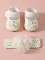 Nahaufnahme von cremefarbenen Baby-Spitzenschuhen und Blumen-Stirnband mit Perlen - Beige