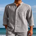 Detailed view of a men's grey striped linen shirt with stand collar against beach backdrop. - S / Tops / Gray