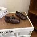 Mocassins pour enfants marron foncé classiques sur une surface en bois dans un décor chaleureux - Taille 22 (Longueur Intérieure 14,5 cm) / Marron