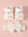 Nahaufnahme von niedlichen Baby-Spitzenschuhen und passendem Stirnband mit Schleifen - Beige