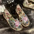 Close-up of decorative floral and rhinestone embellishments on floral flat sandals - 35 / Gold