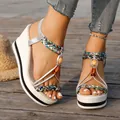Close-up of bohemian wedge sandals with braided straps and bead details on a wooden deck - 36 / Silver