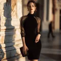 Vista detallada de un elegante vestido de noche negro con mangas de malla transparente. - S / Vestidos / Negro