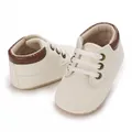 Detailed macro view of cream and brown baby walking shoes with soft flexible soles - Inner Length 11cm / Off White