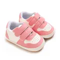 Pink and white baby walking shoes with soft rubber sole and dual velcro straps detail. - Pink