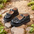 Classiche scarpe Mary Jane nere per bambine con fiocco e suola spessa in un giardino - 26 / Nero