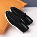 Pair of premium black suede loafers with white soles resting on an orange pillow prop - 39 / Black