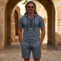 Männliches Model trägt ein graues Kapuzen-T-Shirt mit Schnürung und Cargo-Shorts - Grau