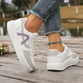 Close-up detail of women's white thick-soled sports sneakers on outdoor wooden deck - 36 / Off White