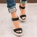 Close-up view of stylish black ankle strap wedge sandals with a woven espadrille platform sole - 35 / Black