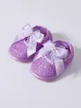 Close-up of purple infant walking shoes featuring lace overlay and elegant pearl bow - Purple