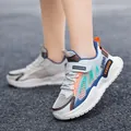 Zapatillas de correr de malla transpirable para niños en blanco con detalles naranja y azul - Beige