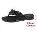 Detailed close-up view showing the 2.7cm heel height of these black floral thong sandals - Black