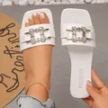 Close-up of white square toe flat slides with rhinestone chain buckle detailing - 35 / White