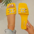 Detailed view of yellow square-toe flat sandals featuring a sparkling crystal buckle ornament - 35 / Yellow