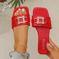 Detailed view of red square-toe flat sandals featuring a decorative rhinestone buckle - 35 / Red