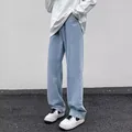 Detailweergave van de lichtblauwe herenjeans met rechte pijpen op een model gedragen - Lichtblauw