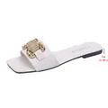 Close-up view of white flat slide sandal featuring elegant gold metal buckle detail. - 35 / White