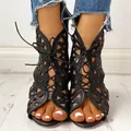 Detaillierte Frontansicht von schwarzen flachen Sandalen mit Ausschnitten und Schnürung im Ethno-Stil - Schwarz