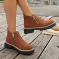 Detalle de cerca de botines de ante marrón con cremalleras laterales y suelas gruesas - Tostado