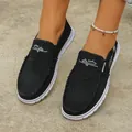 Detailed view of black canvas slip-on loafers with frayed edges and white embroidery detail. - 36 / Black