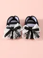 Close-up detail of black newborn princess shoes with elegant white lace and satin bows - Size 11 (Inner Length 10.5CM) / Black