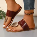 Stylish brown crocodile-patterned flat sandals with a decorative gold metal disc. - 36 / Brown