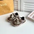 Primo piano di scarpe sportive leopardate per bambini con mesh traspirante e suole morbide - Kaki