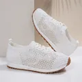 Dettaglio di sneaker in rete traspirante bianca da donna con motivo floreale - Bianco