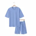 Detailansicht eines hellblauen Herren Sommer T-Shirt und Shorts Sets auf Holzbügeln - Hellblau