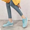 Vue détaillée de baskets en maille pailletée bleu clair avec d'épaisses semelles blanches. - Bleu clair