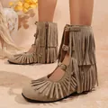 Detailaufnahme stilvoller taupefarbener Fransenstiefel mit Schnallen und Wildlederoptik - Khaki