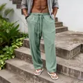Detailed view of casual men's loose sage green linen pants featuring a drawstring elastic waist. - Grey Green