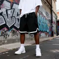 Detail view of black checkered loose shorts for men in an urban street style alley - S / Bottoms / Black