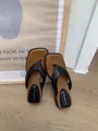 Gros plan sur des tongs noires à bout carré avec une semelle intérieure marron confortable - Noir