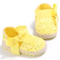 Vista detallada de zapatos amarillos de ganchillo para bebés con lazo y suela blanda - Amarillo