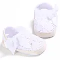 Primer plano detallado de zapatos de bebé de ganchillo blanco con gran lazo suave - Blanco
