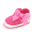 Vue détaillée d'une chaussure de marche bébé rose en dentelle avec un grand nœud - Pêche