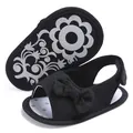 Detailed view of black baby girl sandals featuring a cute bow and floral soft sole - Black