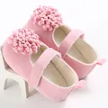 Vista detallada de zapatos rosa para bebé con suelas blandas y flores decorativas 3D - Rosa