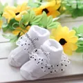 Close-up view of white baby princess socks with lace ruffles and polka dot bows - 0-6 Months / White