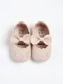 Top view of pink baby princess shoes with leather bows and delicate floral embroidery. - Apricot