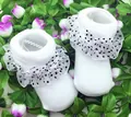 Detailansicht weißer Baby-Festtagssocken mit schwarzen Punkten, Spitze und Schleifen - 0-12 Months / Weiß